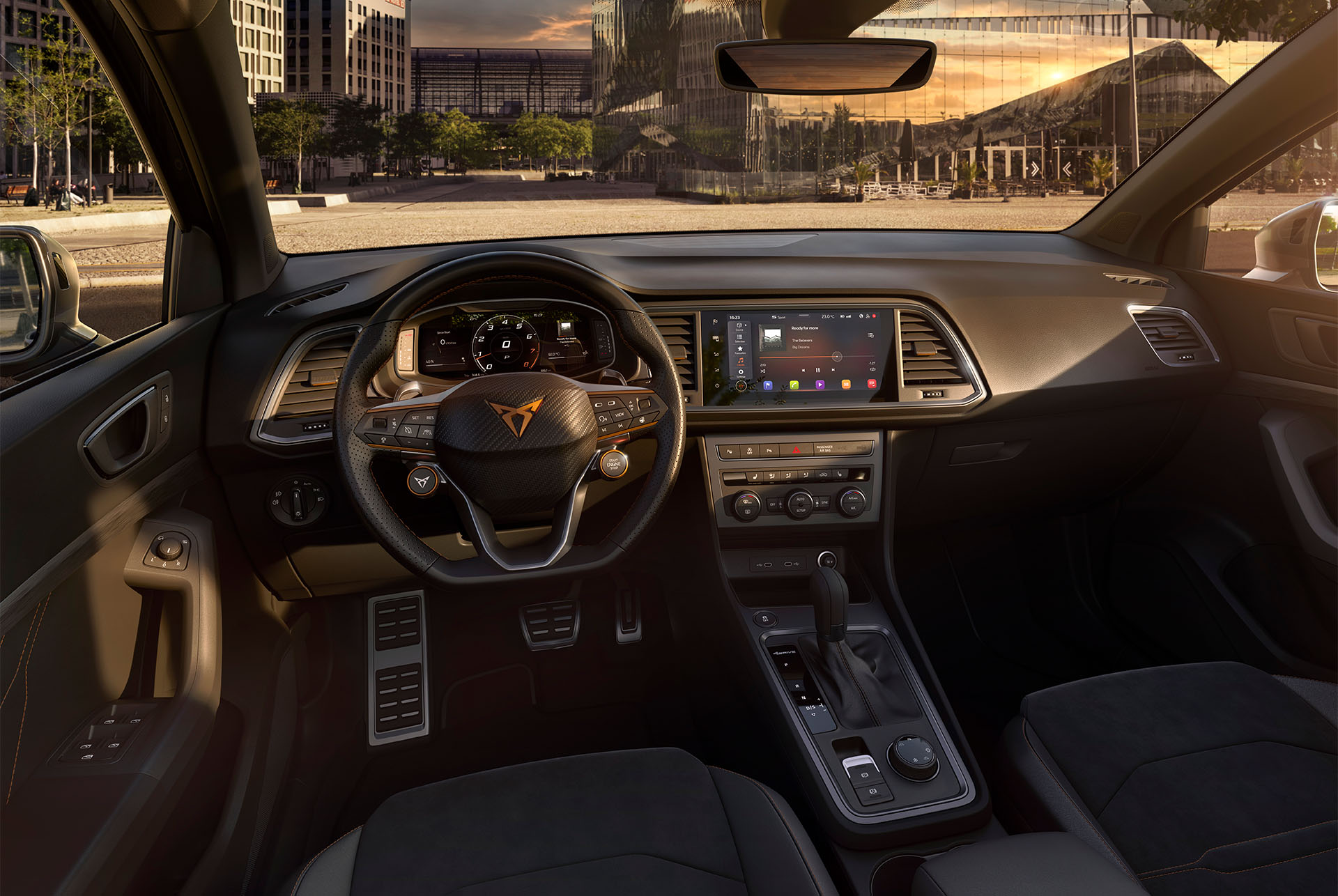 Interior view of the CUPRA Ateca SUV, showcasing the steering wheel with satellite buttons for engine start and drive profile selection. Paddle shifters behind the wheel offer convenient gear shifting. 